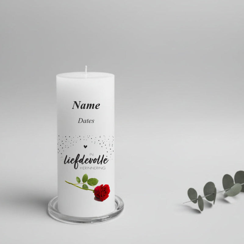 White memorial candle with Afrikaans text and a red rose on a gray background