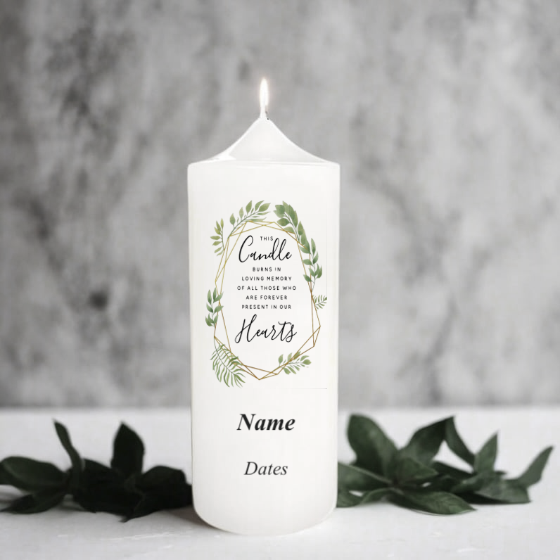 White memorial candle with green leaf design and text on a gray background