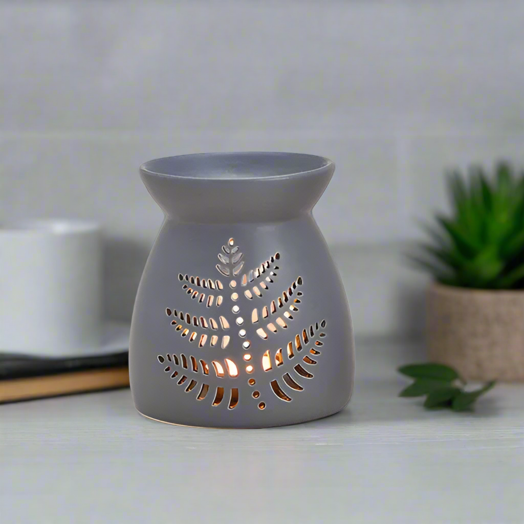Gray ceramic oil burner with leaf design on a white background