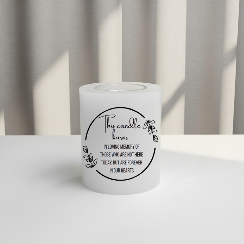 White memory candle with a message on it against a striped curtain background