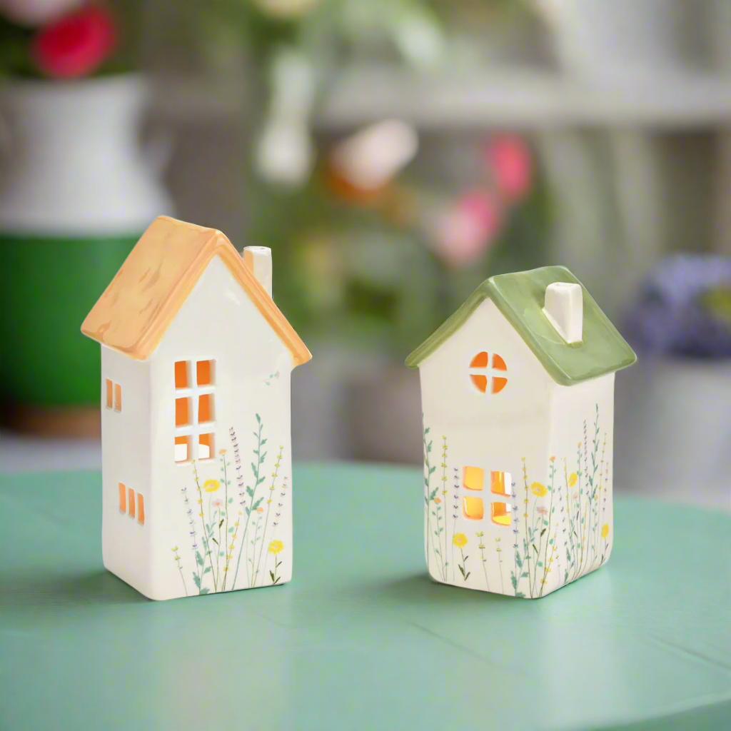 Two ceramic house-shaped lanterns with painted flower decor