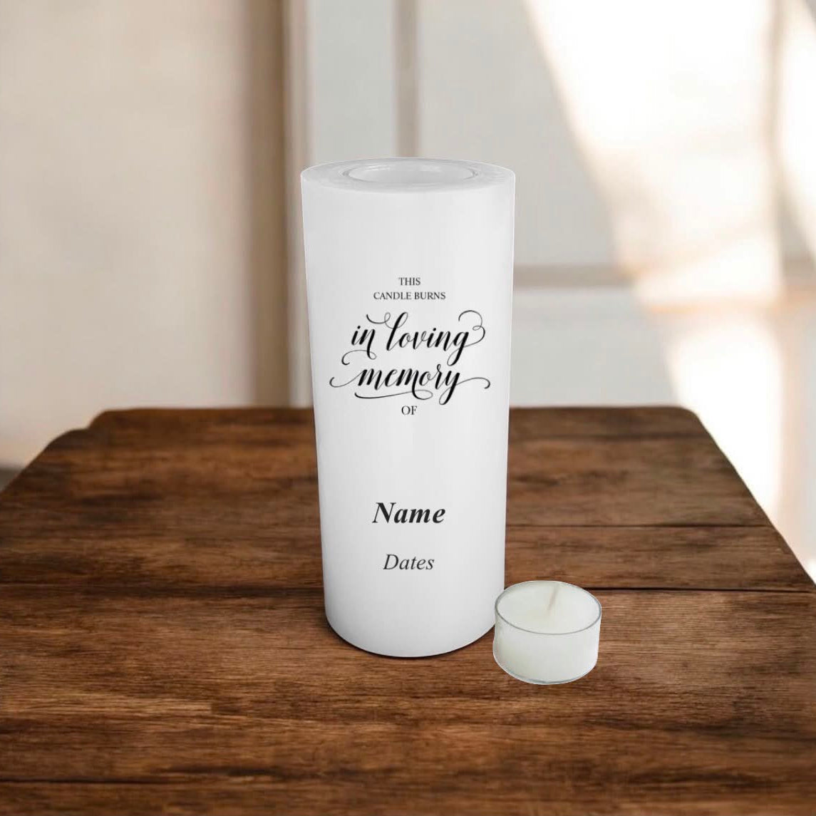 White candle with memory text on a wooden surface