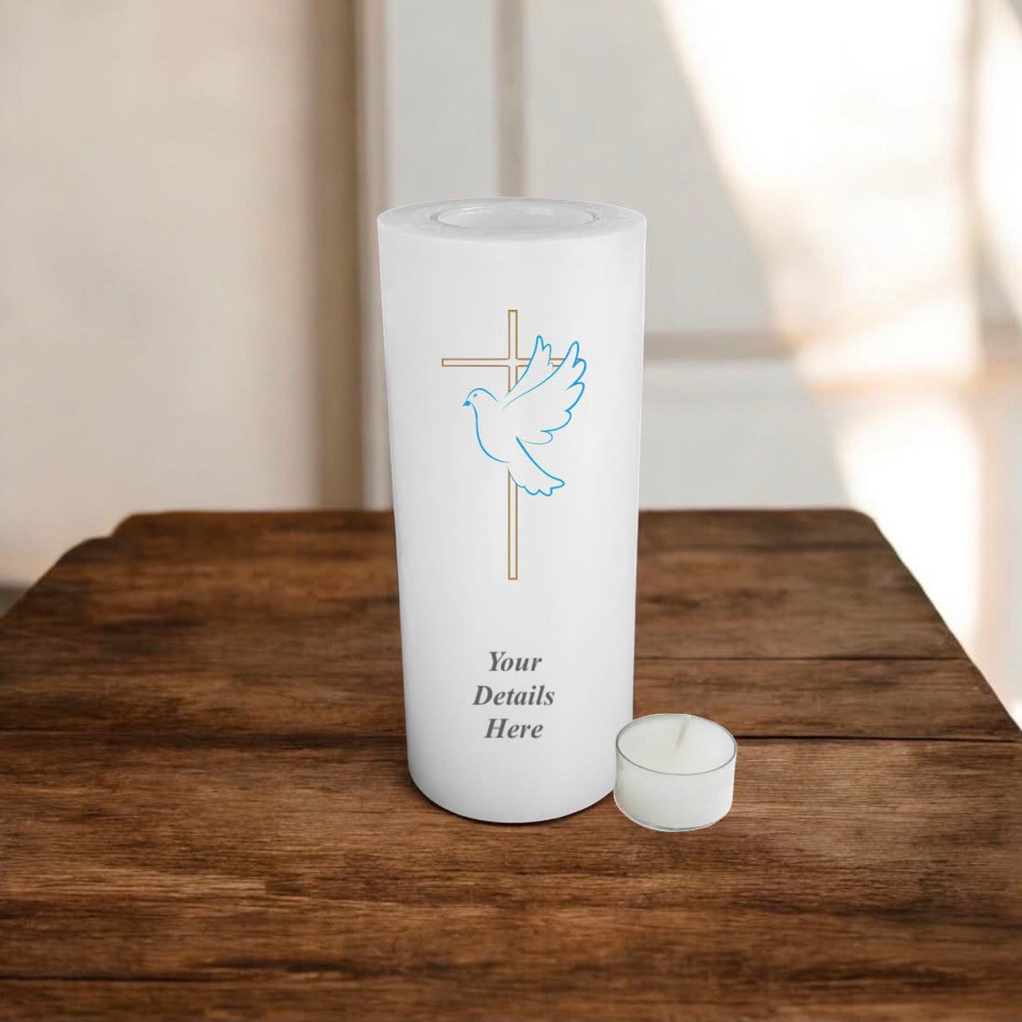 White candle with a gold cross and a dove on a wooden surface with a neutral background