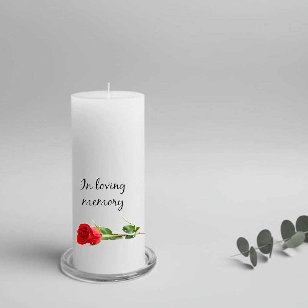 White memory candle with 'In loving memory' text and a red rose on a gray background