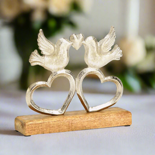 Decorative wedding ornament of two doves on heart shapes with a wooden base on a white background