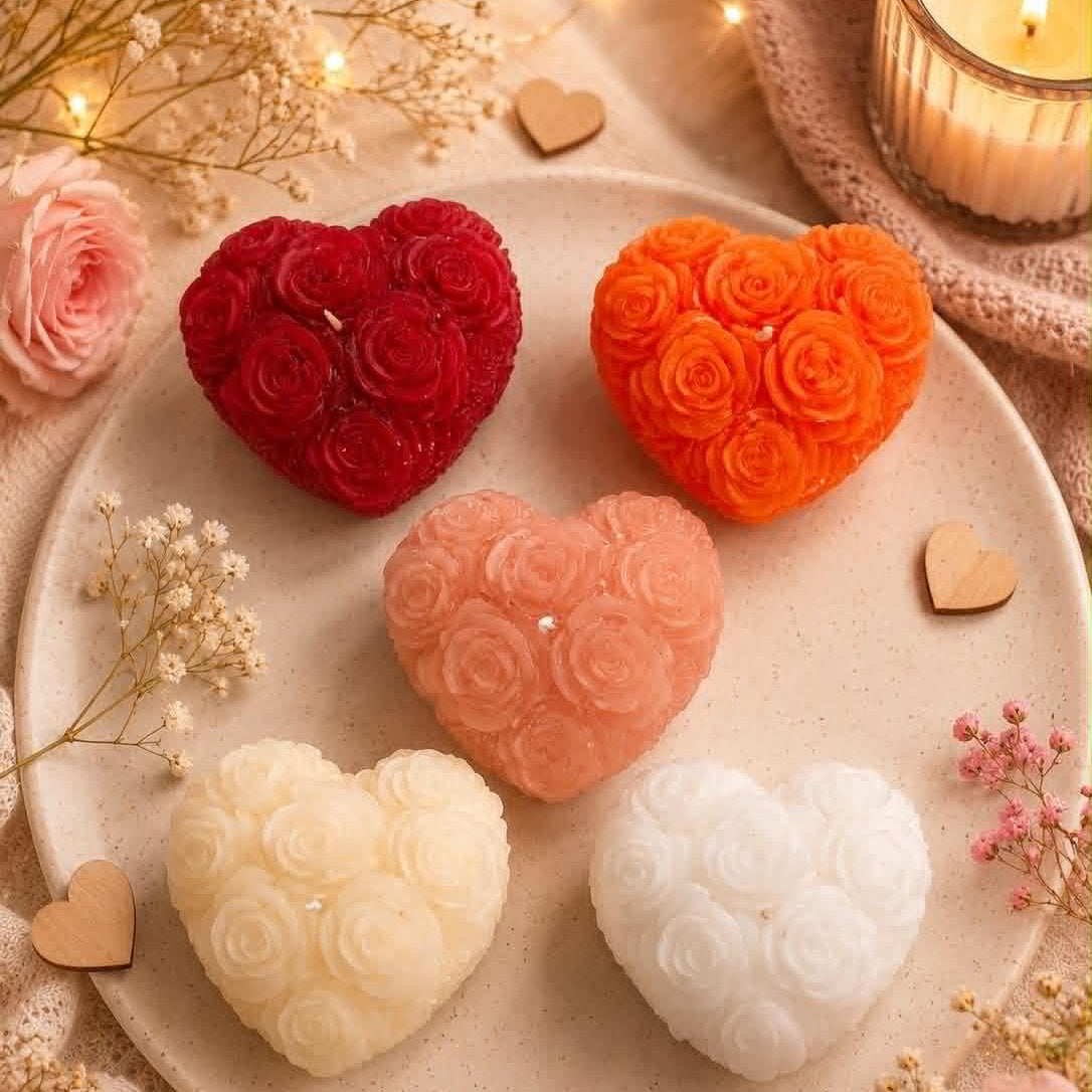 4 heart shaped candles with roses on a plate