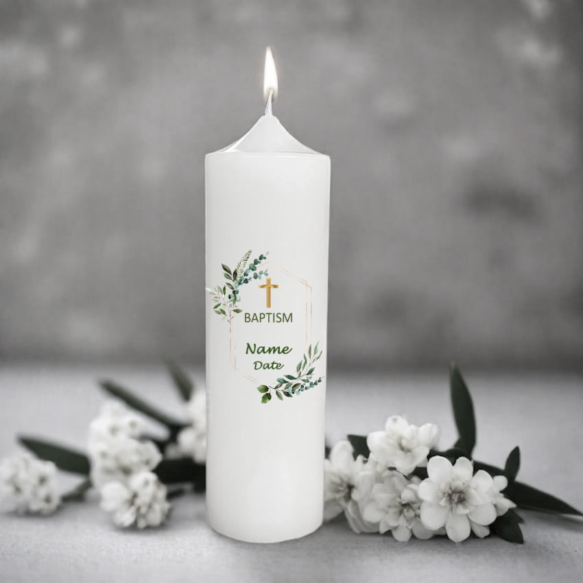 White candle with text and floral design on a grey background with flowers.