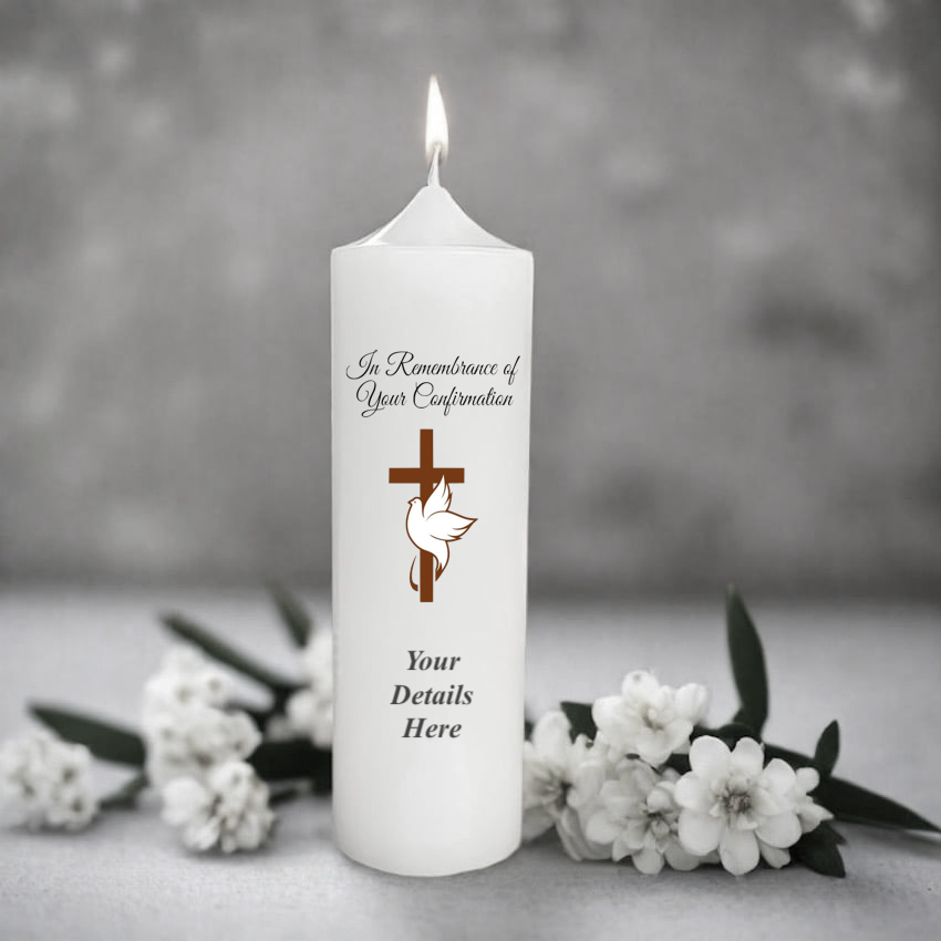 White candle with personalized text and religious symbols on a gray background with flowers.