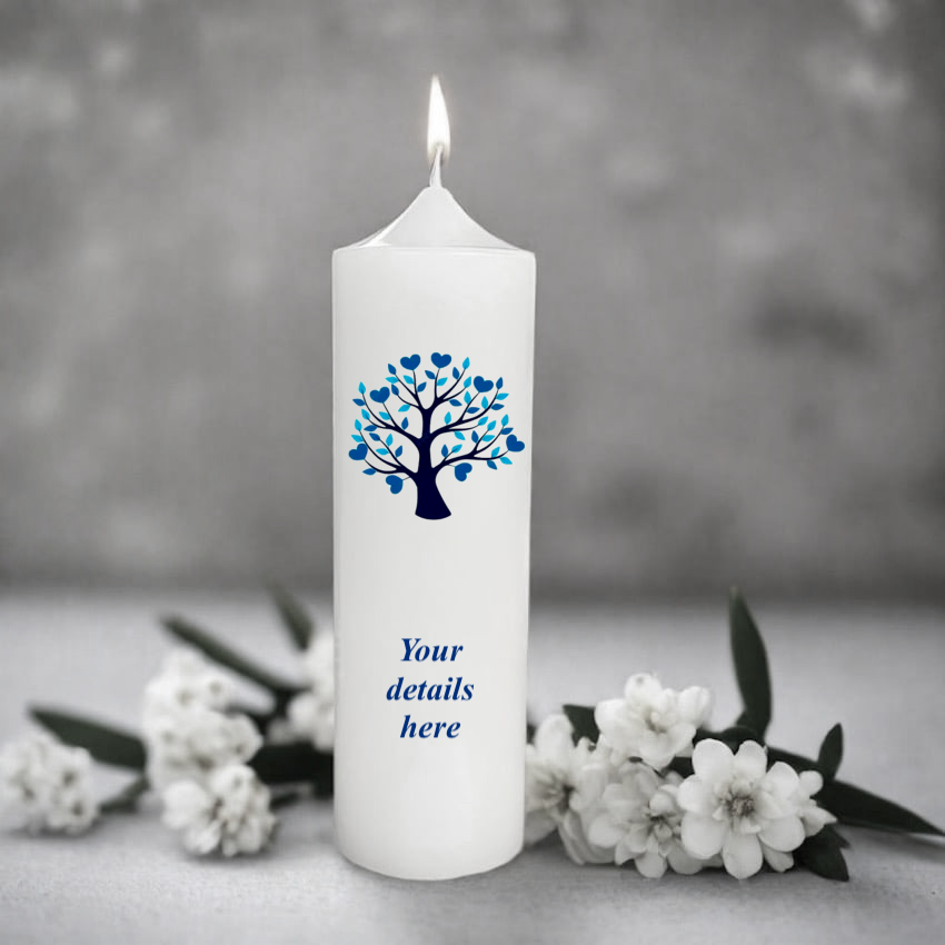 White candle with blue tree design and text placeholder, surrounded by white flowers on a gray background