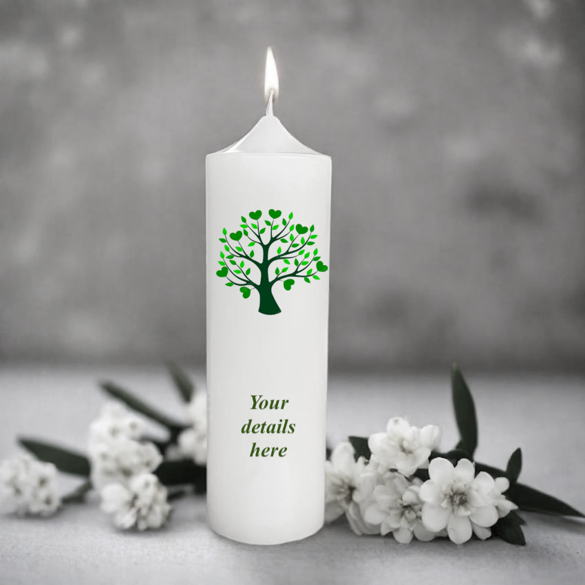 White candle with green tree design and text placeholder on a gray background with flowers.