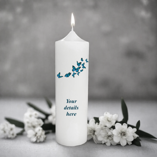 White candle with blue butterfly design and placeholder text 'Your details here' on a gray background with white flowers.