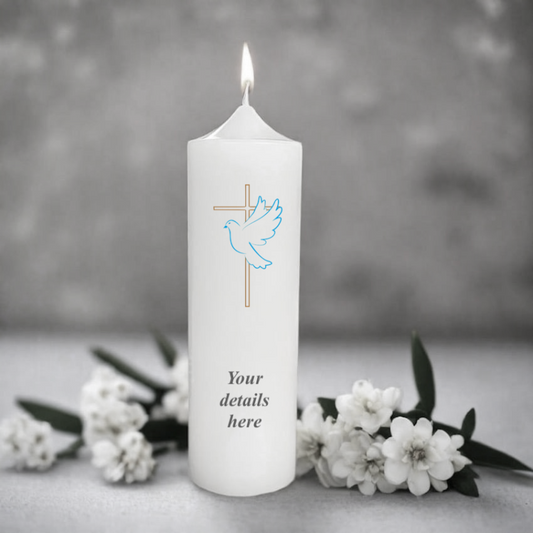 White candle with a dove and cross design.