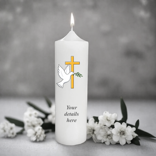 White christening candle with a cross and dove design, surrounded by white flowers on a gray background