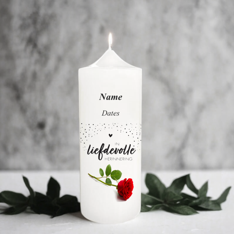 A white candle printed in Afrikaans, and a red rose with green leaves.