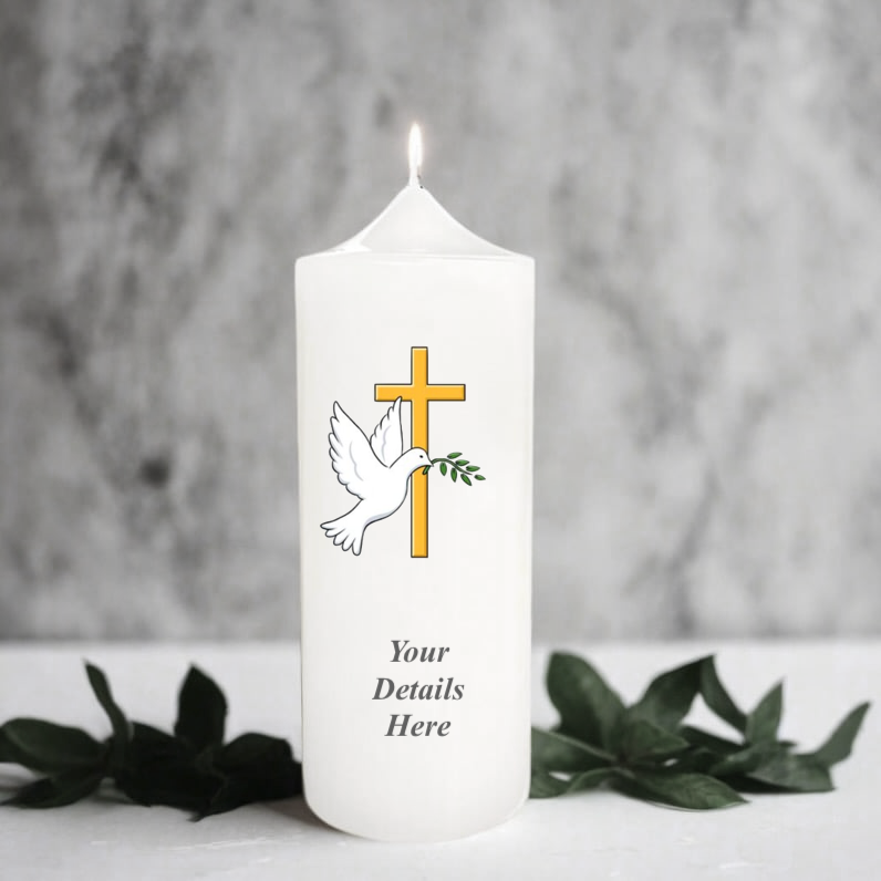 White candle with a cross, dove, and olive branch design on a gray background