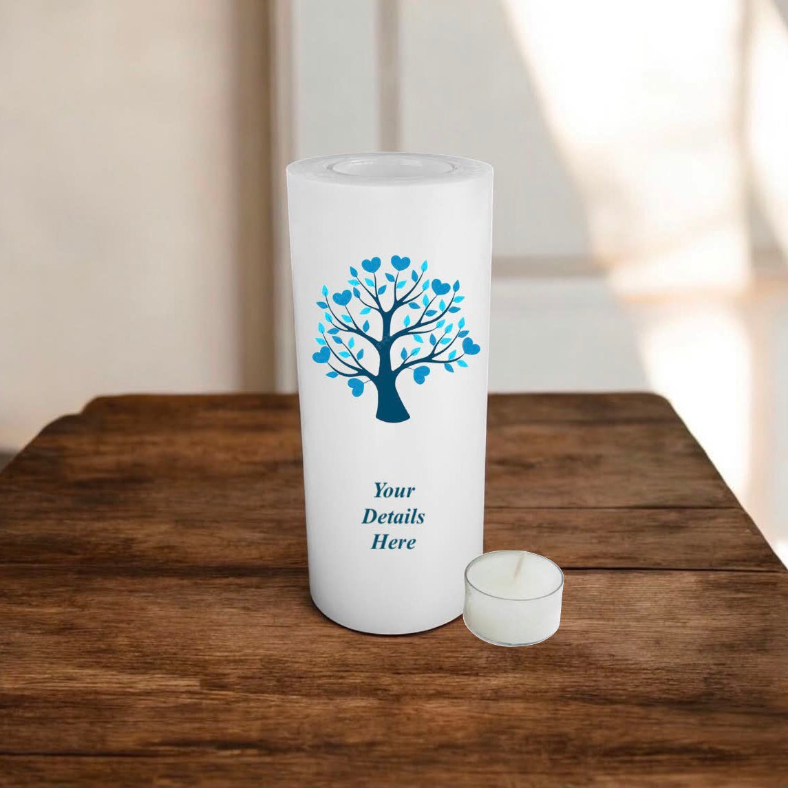 White candle with blue tree design and 'Your Details Here' text on a wooden surface.