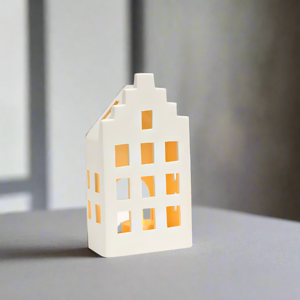 White house-shaped ceramic lantern with tealight inside on a grey background
