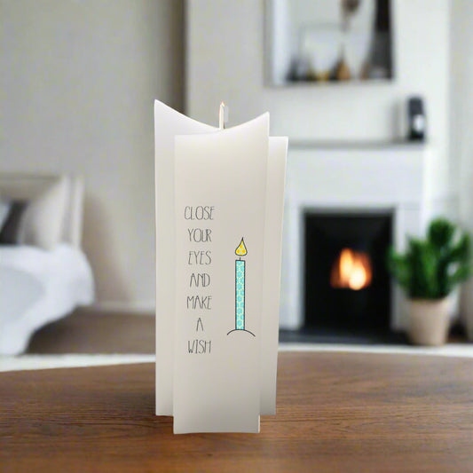 A white art candle with a printed birthday message.