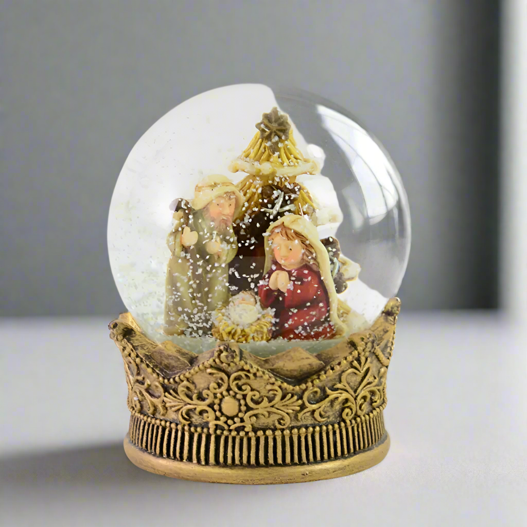 Decorative snow globe with nativity scene on a grey background