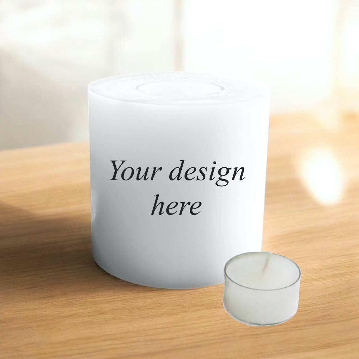 A white candle standing on a light wood surface, with the text 'Your design here' printed on the front. The background is softly blurred with bright light.