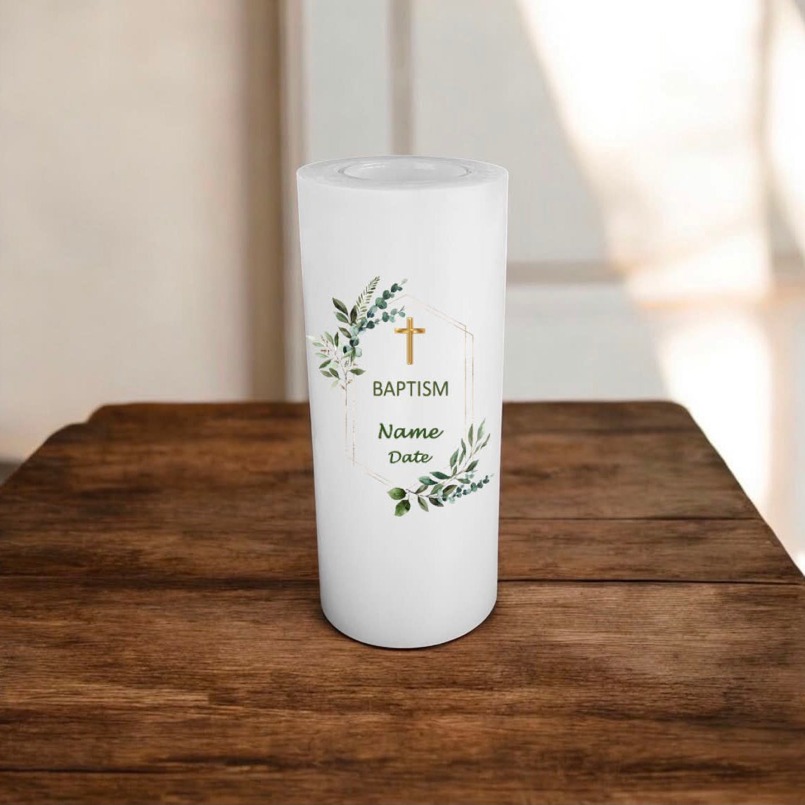 White candle with 'Baptism' text and cross design on a wooden surface