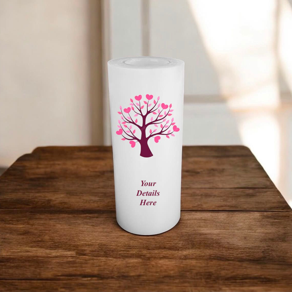White candle with a pink tree design and customisable text on a wooden surface.