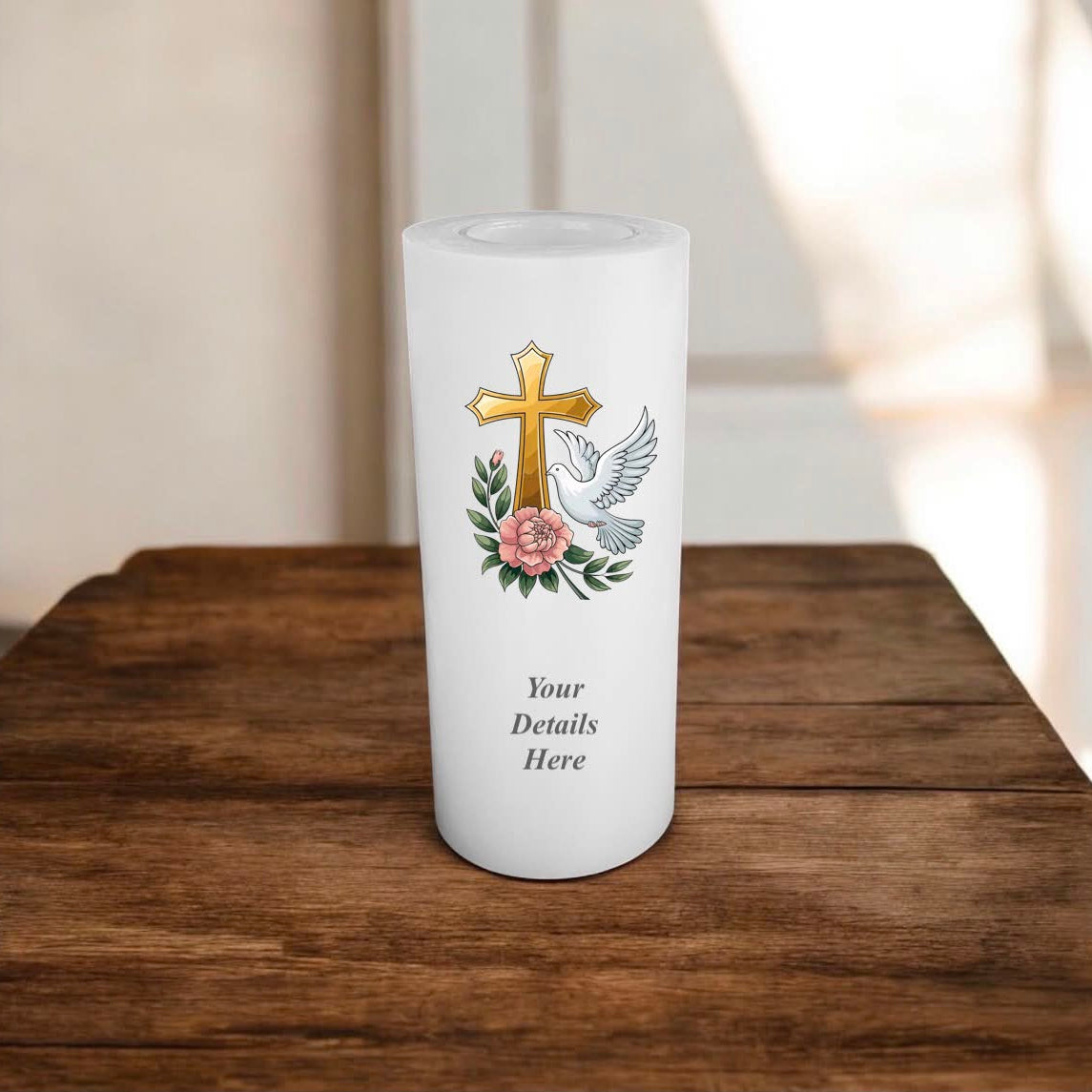 White candle with a cross and dove design on a wooden surface