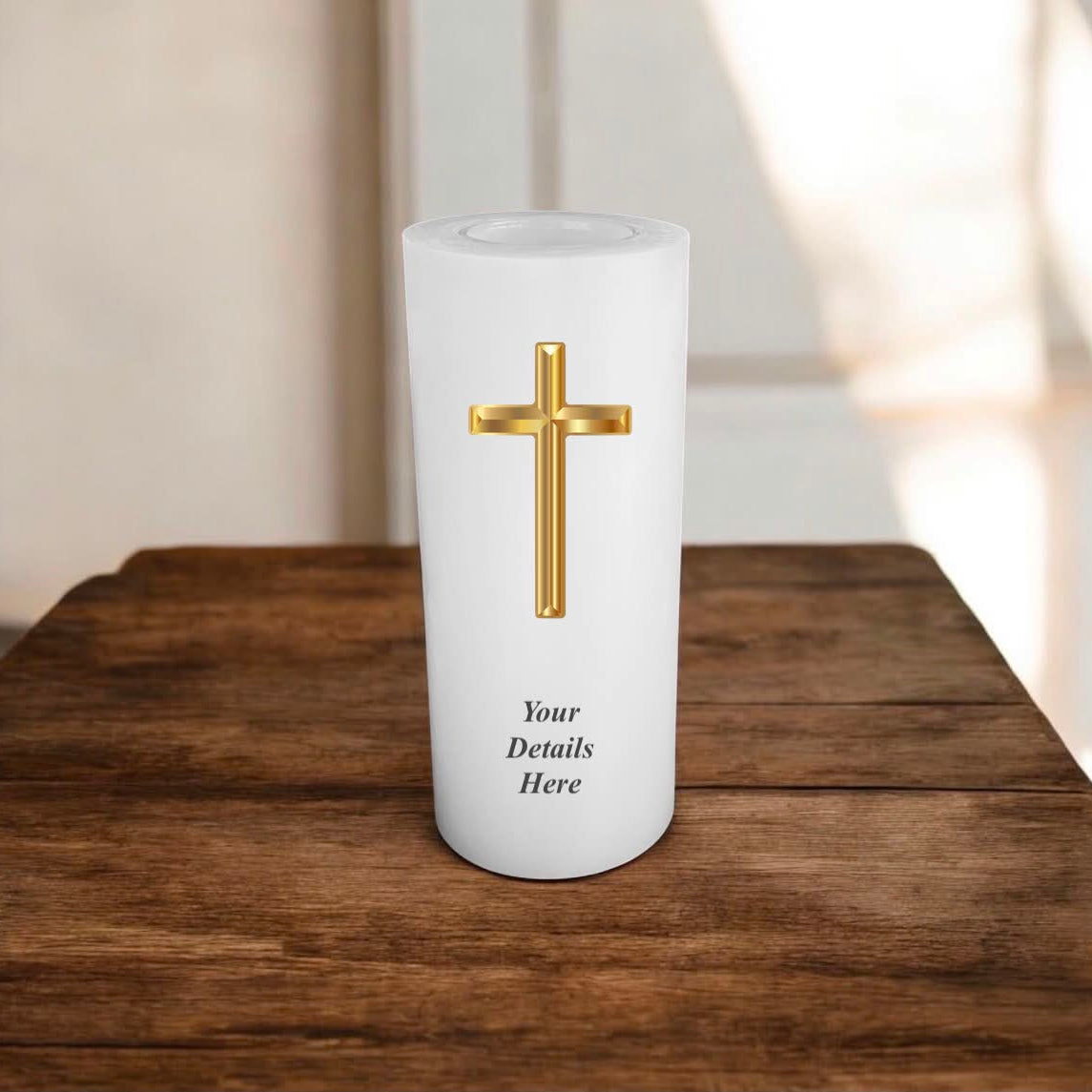 A white candle with gold cross on a wooden surface.