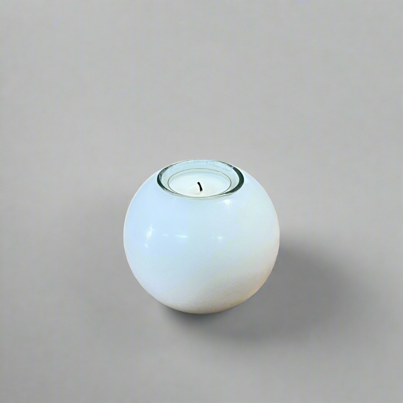 A white ball candle with a built-in glass holder to place a tealight or a flameless LED tealight.