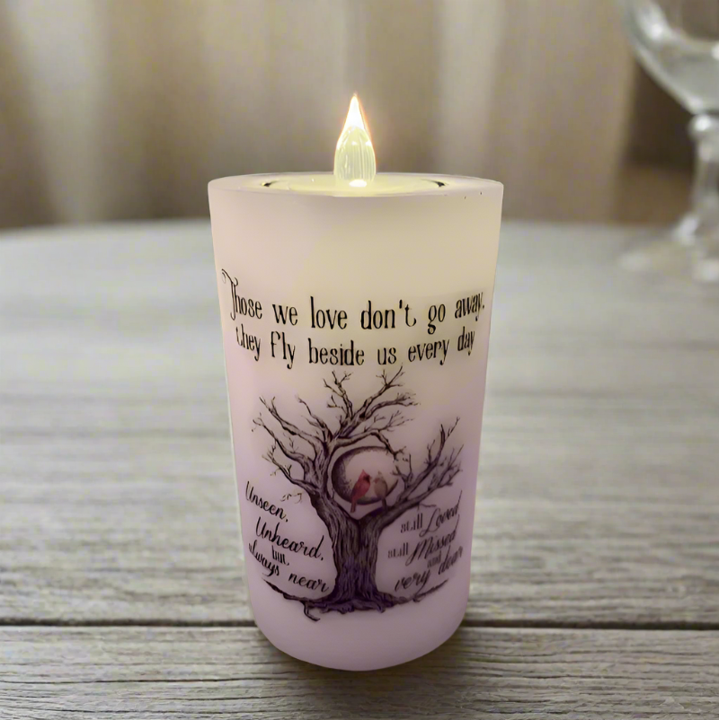 A white candle with a built-in glass holder and a flameless LED tealight.