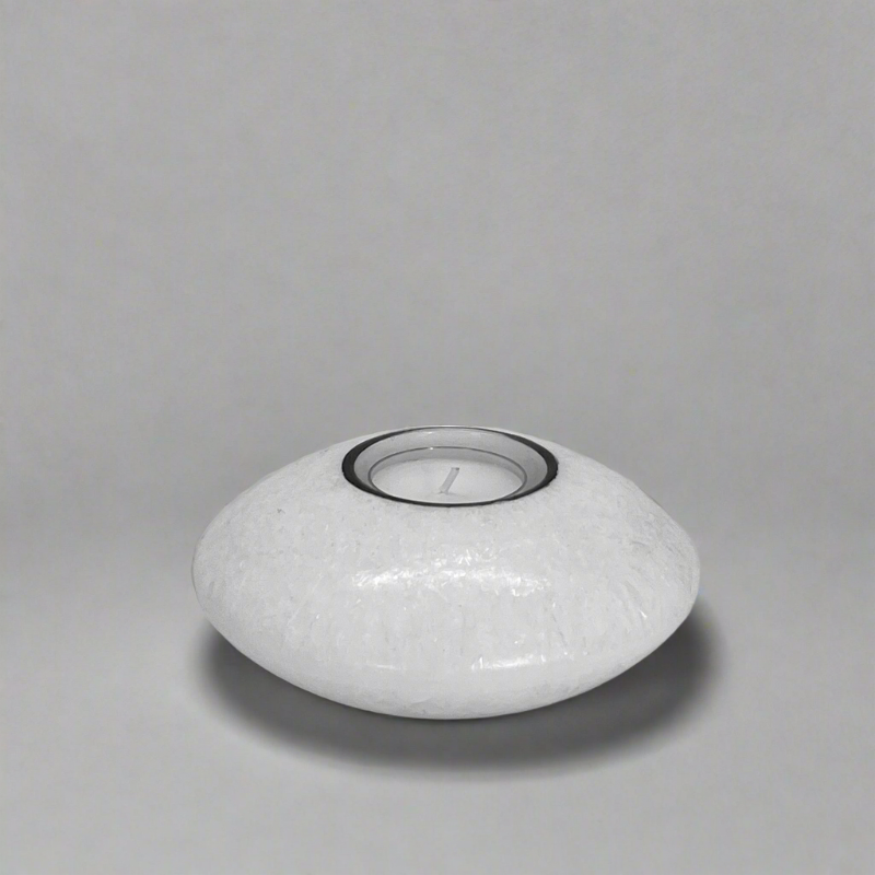 A white discus candle with a built-in glass holder to place a tealight or a flameless LED tealight.