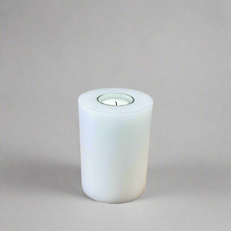 A white pillar candle with a built-in glass holder to place a tealight or a flameless LED tealight.