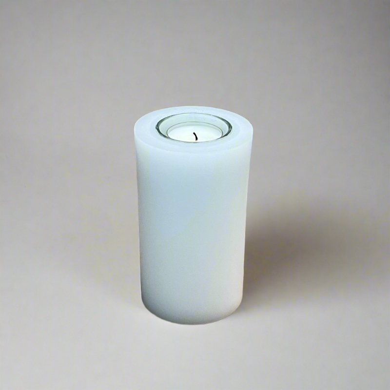 A white pillar candle with a built-in glass holder to place a tealight or a flameless LED tealight.