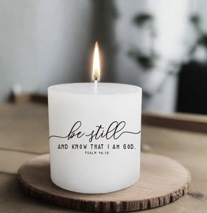 Candle with 'be still and know that I am God' text on a wooden coaster