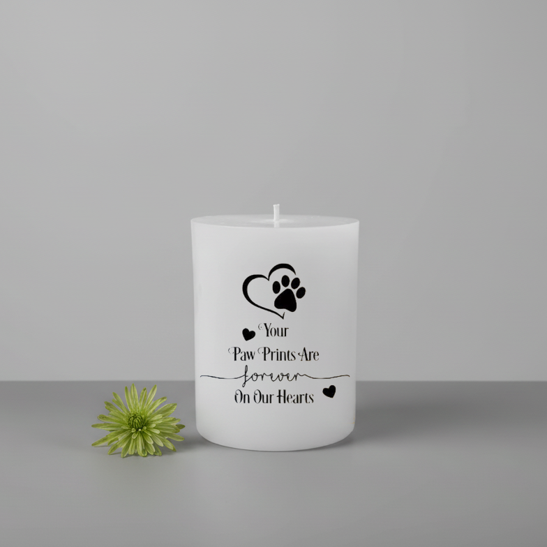 White candle with paw print design and text on a gray background