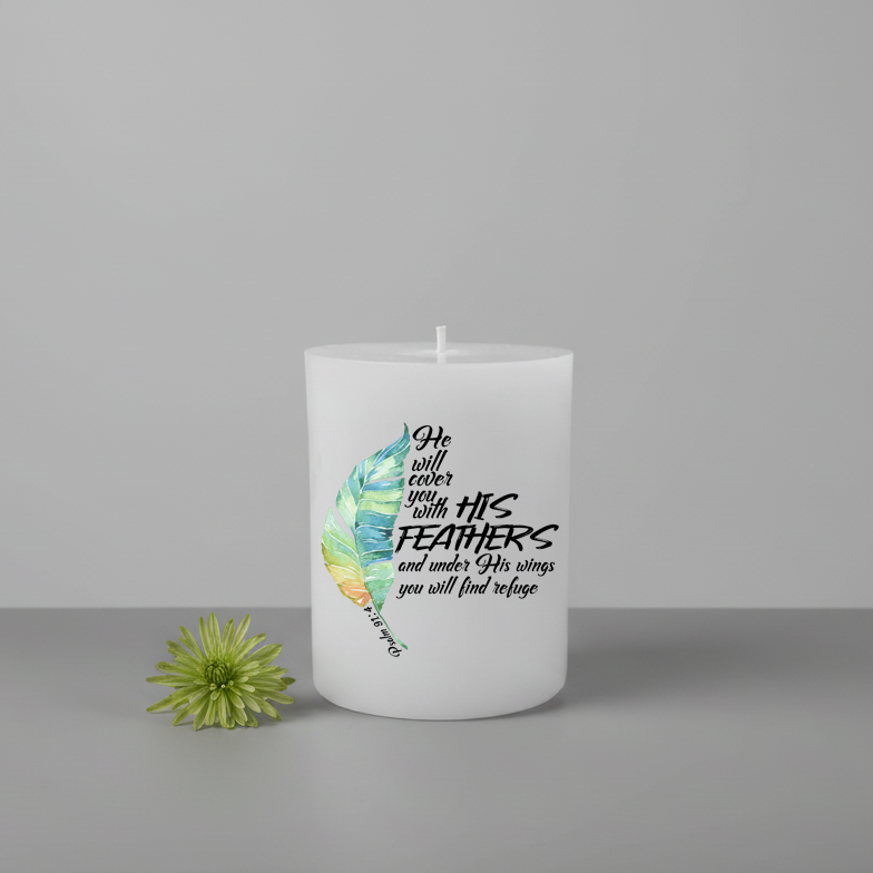 White pillar candle with feather design and text on a grey background