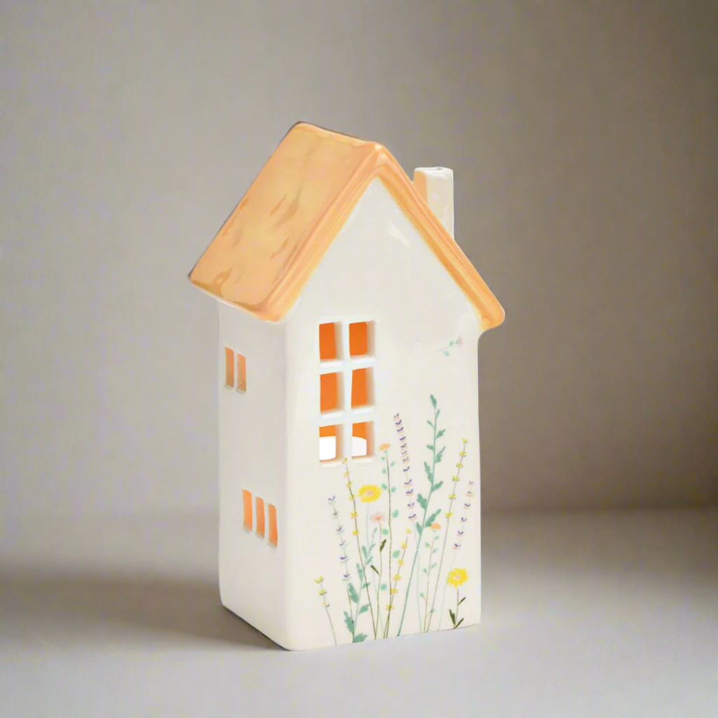 House-shaped decorative lantern with flower decor on a white background
