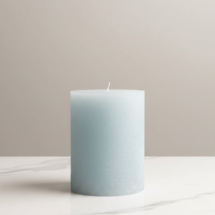 Light blue candle on a table with a neutral background