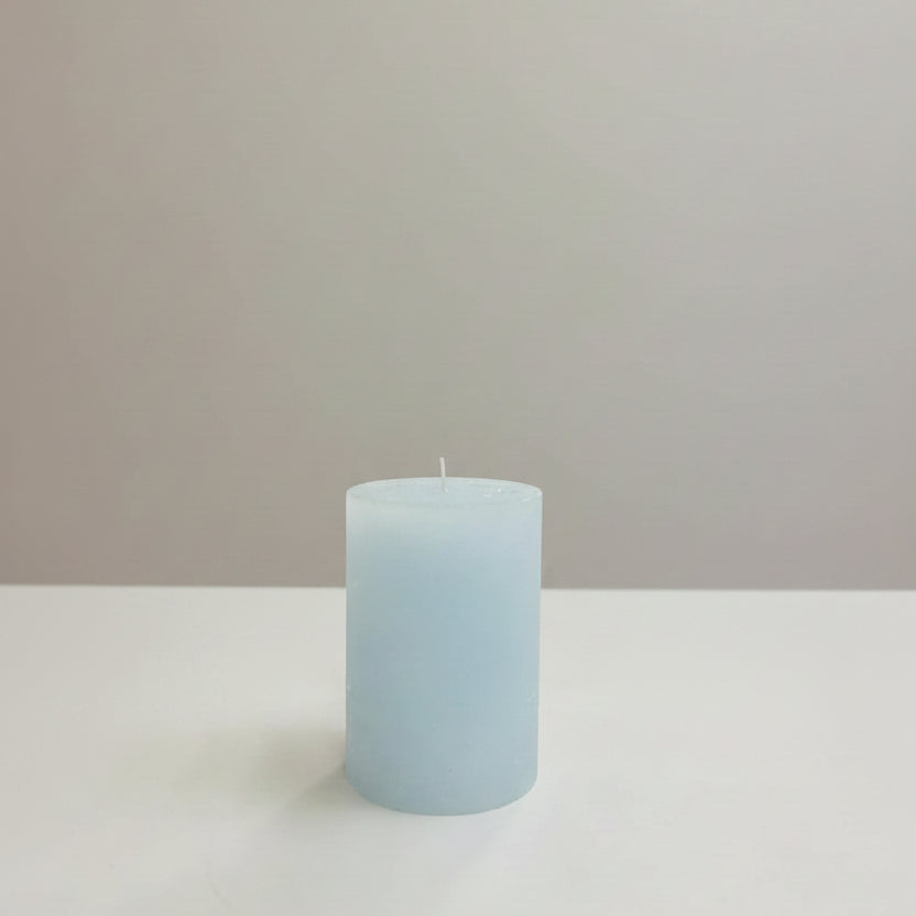 Blue candle on a table with a neutral background
