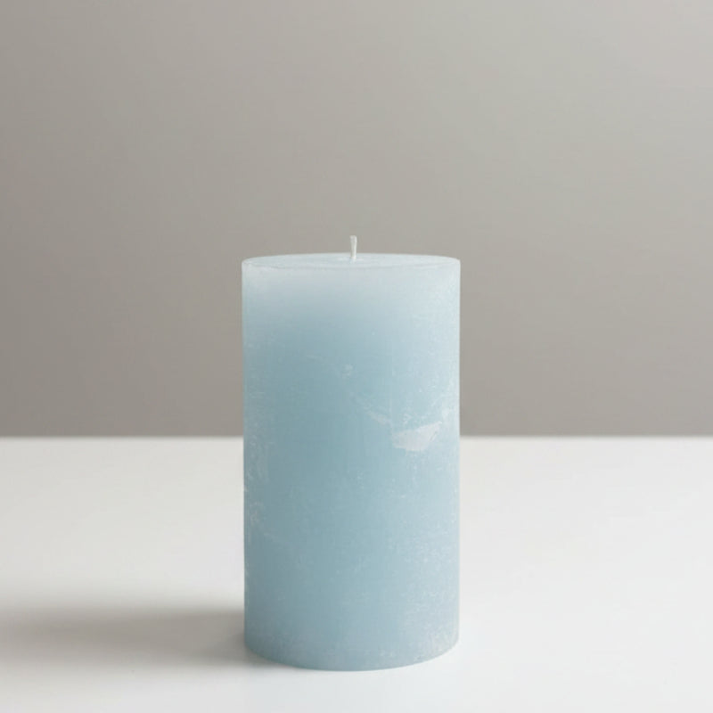 Blue candle on a table with a neutral background