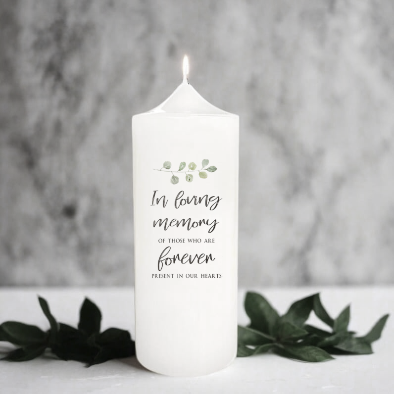 White memorial candle with text and design on a gray background