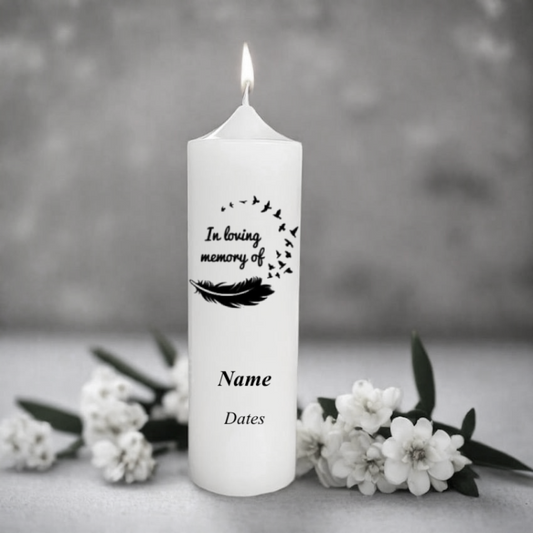 White memorial candle with 'In loving memory of' text and placeholders for name and dates, surrounded by white flowers on a gray background.