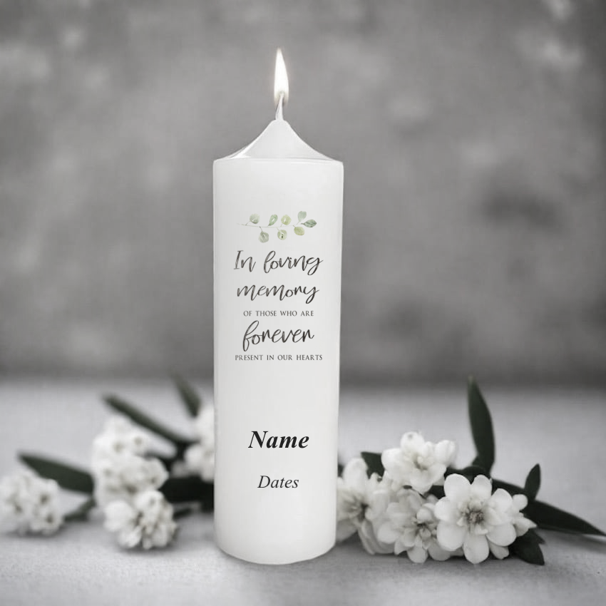 White memorial candle with text and floral design on a gray background