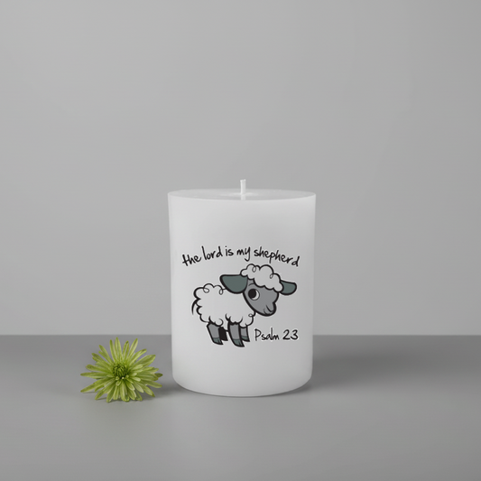 White candle with a sheep illustration and text on a gray background
