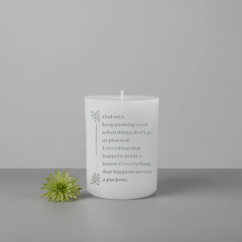 White candle with text and a green flower on a gray background