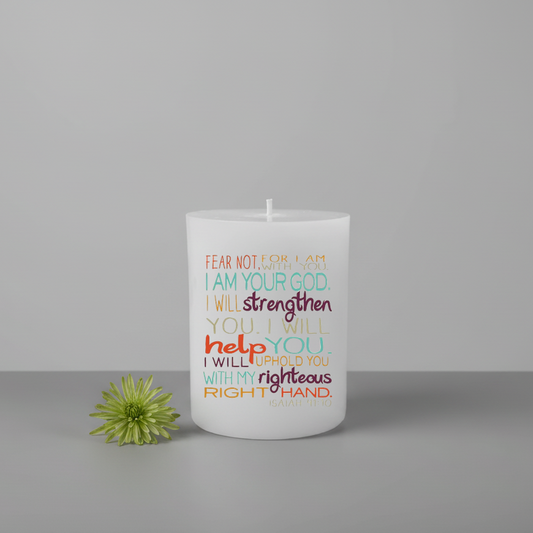 White candle with colorful text and a green flower on a gray background