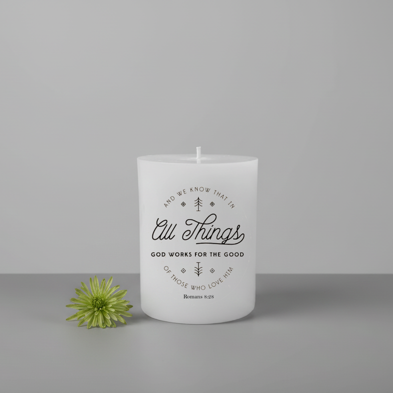 White candle with text and a green flower on a gray background