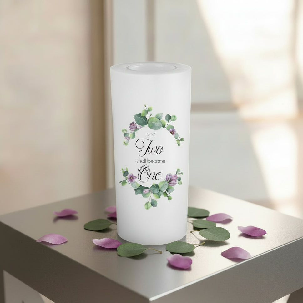 A white candle with a green and purple colors flower design and the union text 