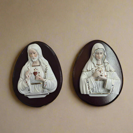 Two religious-themed figurines on a wall