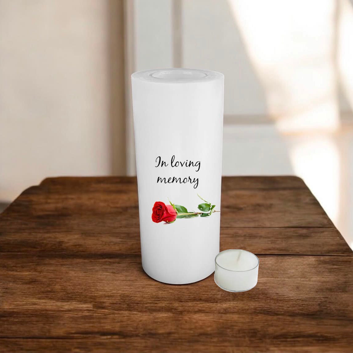 white candle printed with text and a rose on a wooden surface.